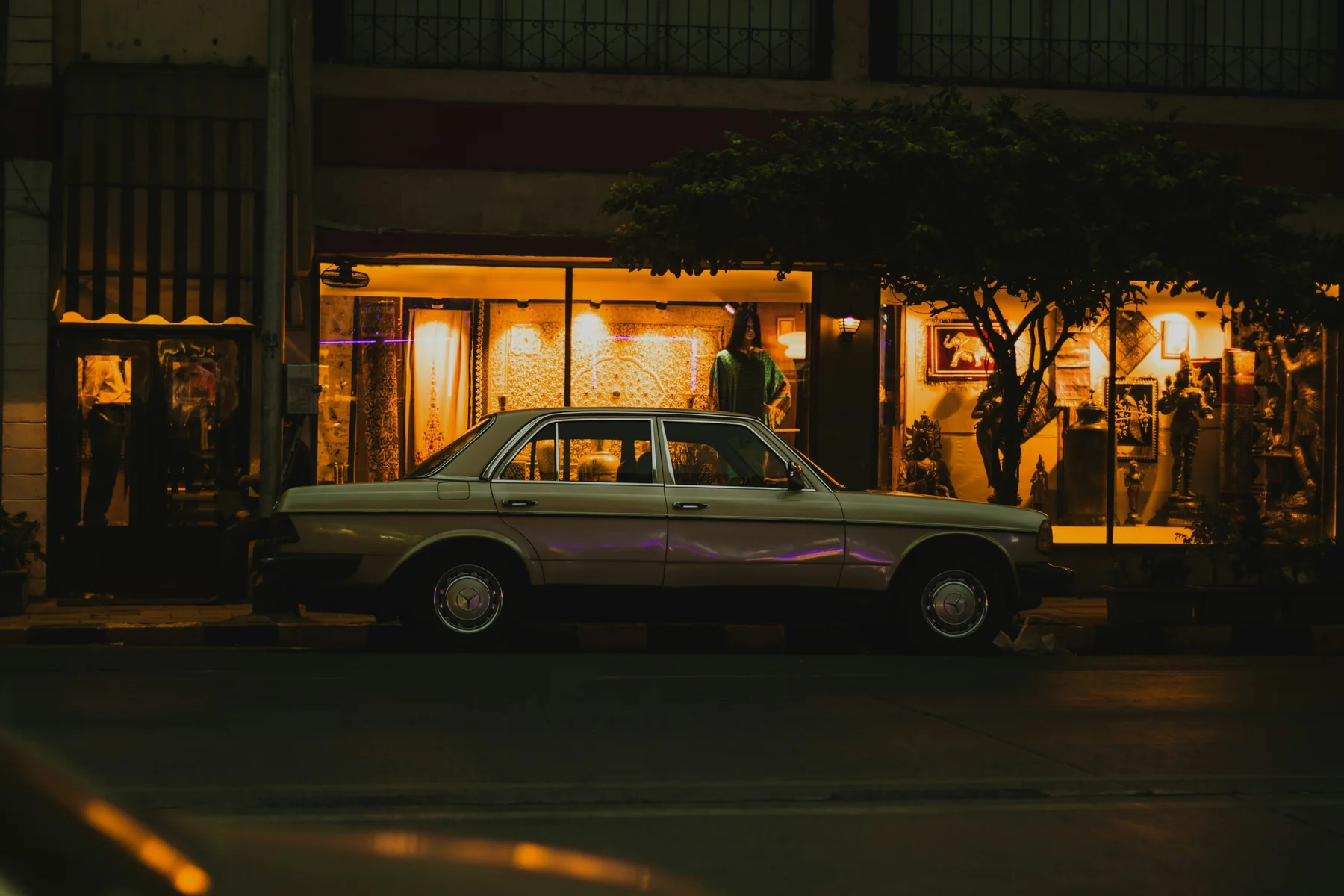 The same car outside a lit restaurant at night, as shot, before Focal develops it