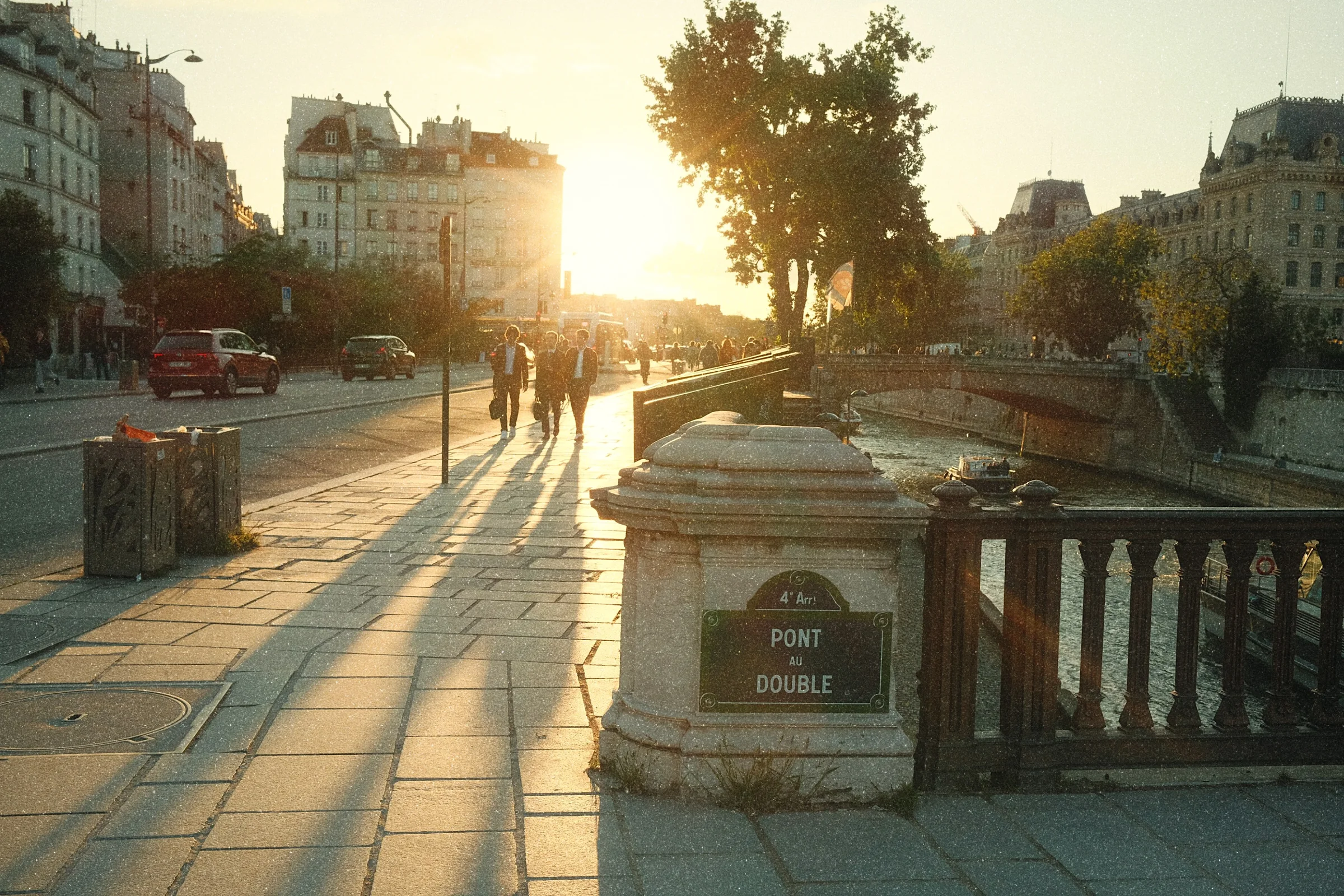 Late sun over the Pont au Double in Paris, people walking towards the light, developed in the Amber look